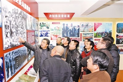 "小尖山突击队"队员参观"硬骨头六连"连史馆,在自己当年的合影前