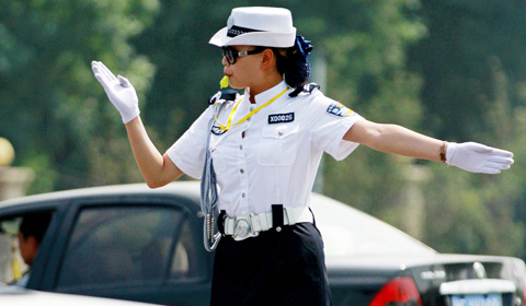 2013年6月16日,河南省安阳市街头,身着夏装的女交警顶着太阳在炎热的