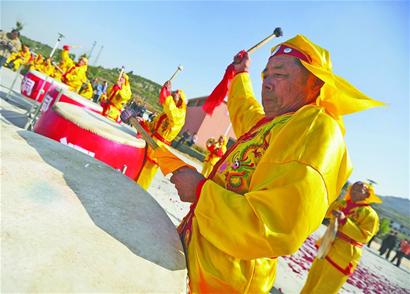 该村锣鼓队在表演"锣鼓经"《九龙翻身》