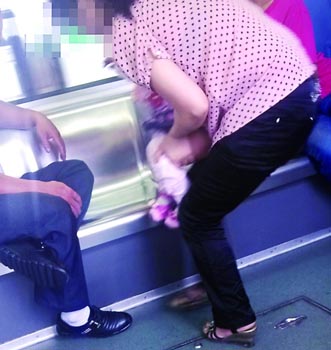 年轻妈妈让小孩轻轨上小便