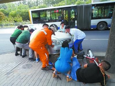 男子腿部被汽车压住好心路人合力抬车救人(图)