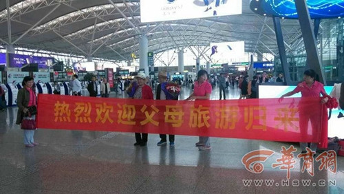 八旬父母旅行归来 五兄妹机场拉横幅欢迎