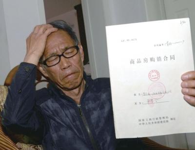 业主拿着购房合同,既▲气愤也很无奈.