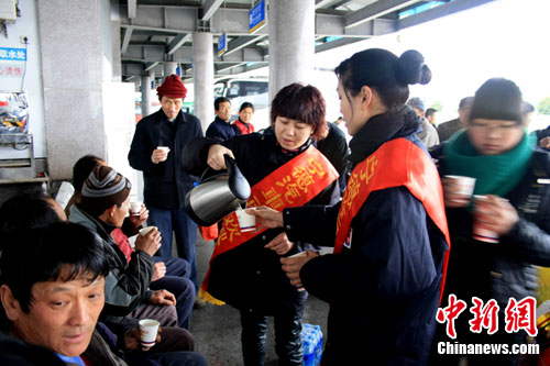由青年站务员组成的志愿服务队伍正在为农民工端茶送水. 林翠慧 摄