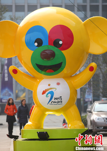 图为市民从2013亚青会吉祥物"圆圆"的形象旁经过.中新社发 泱波 摄