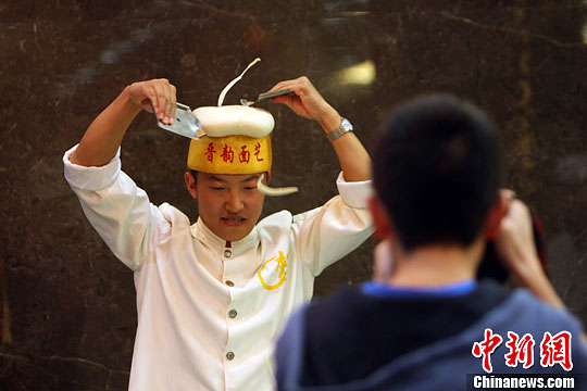 山西面食誉满海内外 厨师表演头顶刀削面