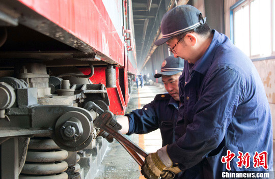 图为沈阳车辆段库检职工正在紧固牵引拉杆.中新社发 于海洋 摄