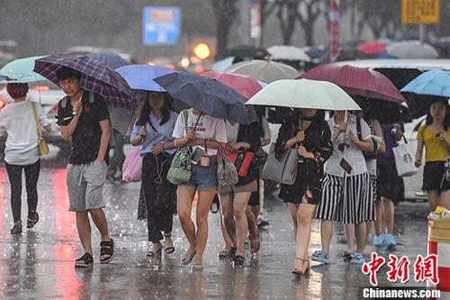 广州九区发布暴雨预警 民众冒雨出行