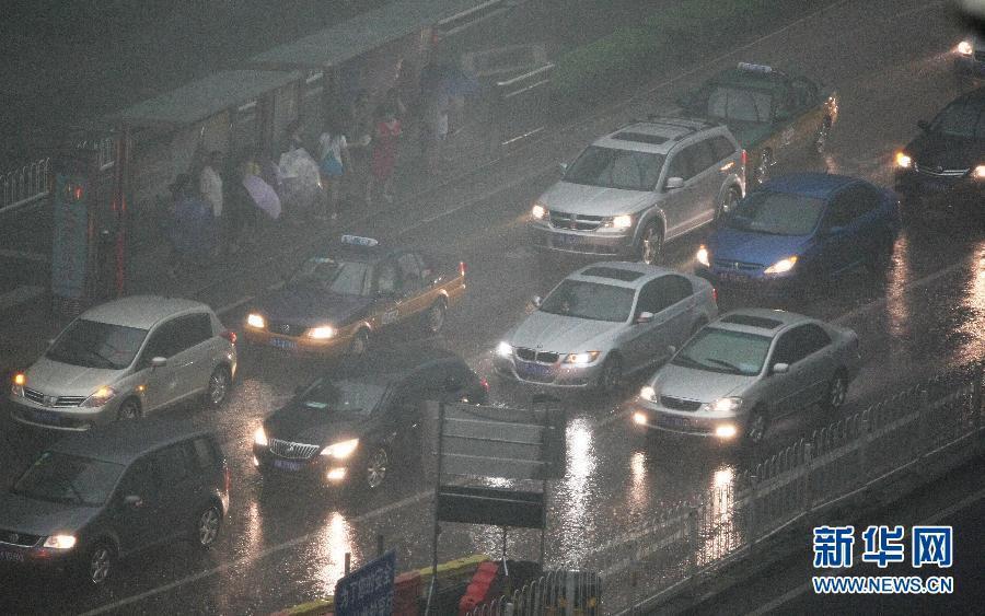 北京暴雨 情侣雨中搀扶前行-中新网