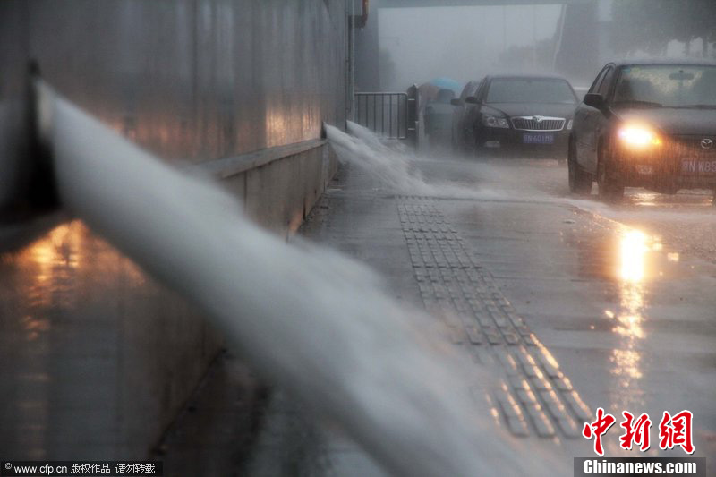 北京暴雨 情侣雨中搀扶前行-中新网