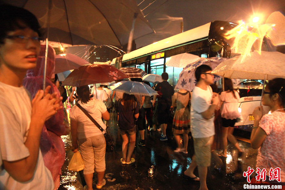 北京暴雨 情侣雨中搀扶前行-中新网