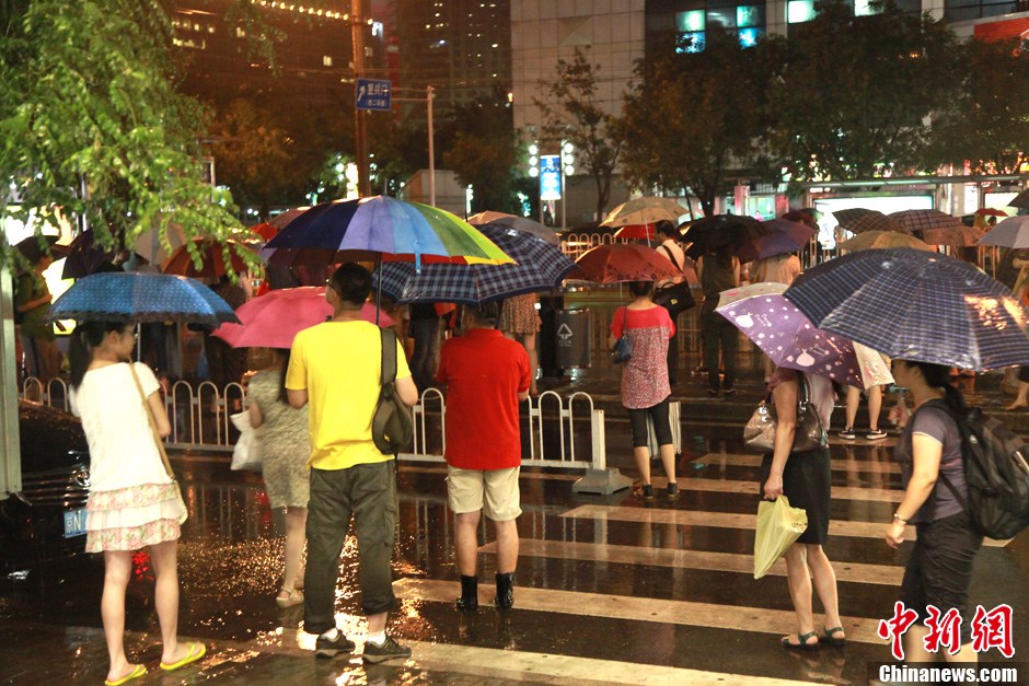 北京暴雨 情侣雨中搀扶前行-中新网