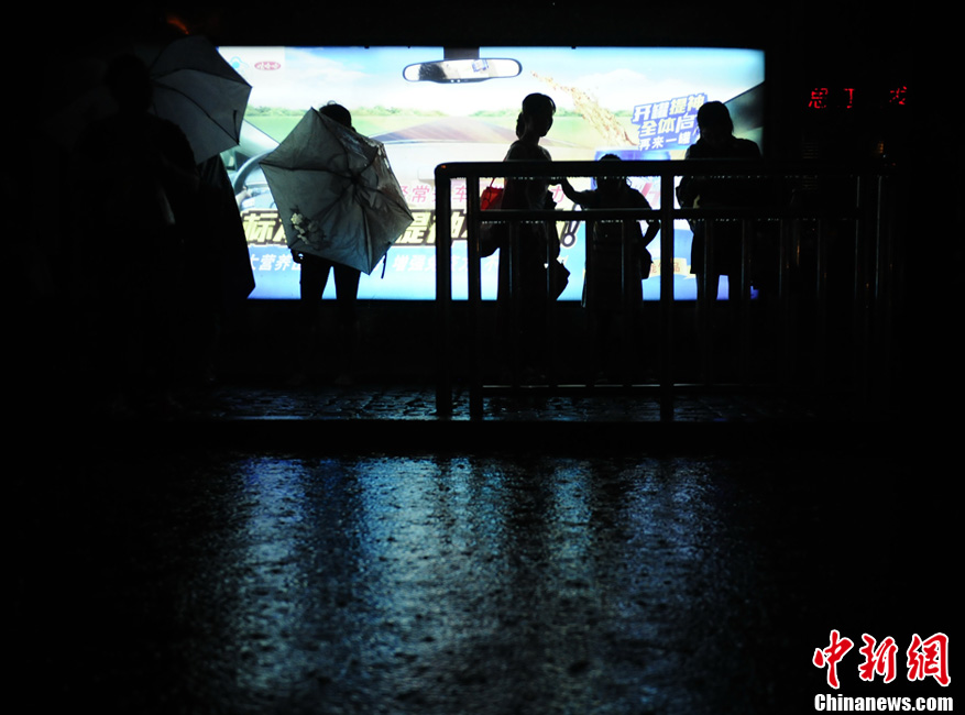 北京暴雨 情侣雨中搀扶前行-中新网
