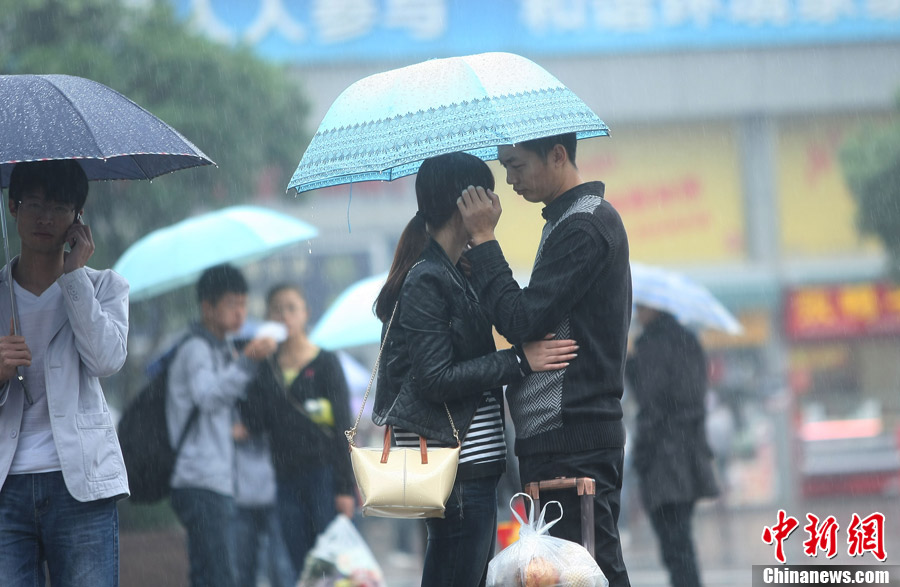 "双节"长假结束 情侣雨中分别依依不舍