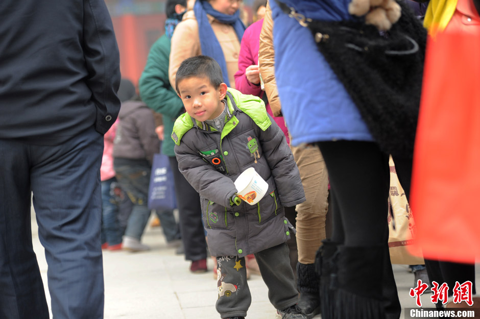 西安大兴善寺施粥忙 小朋友队伍中探头迫不及待