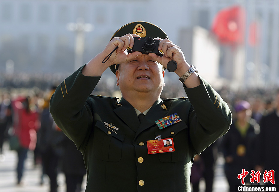 图为全国人大代表,湖南省武警总队总队长赵永平入场时客串摄影师.