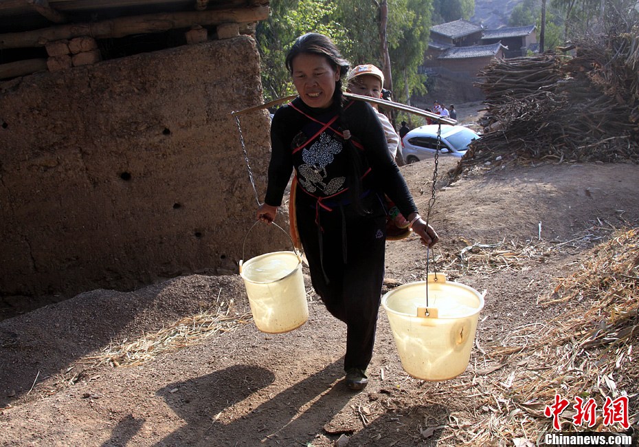 云南干旱灾情严重:村民背孩子挑水回家