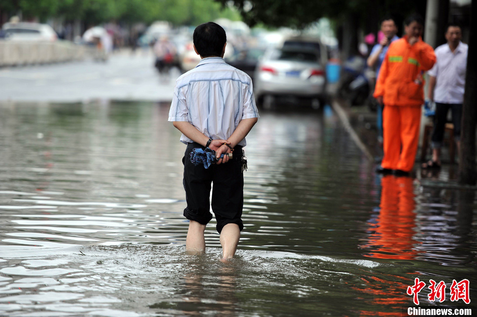 暴雨致南昌内涝 市民卷起裤脚淌水而行