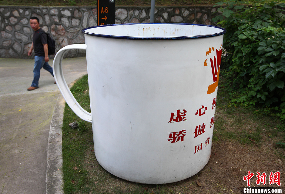 5月14日,一位市民从南京街头的超大搪瓷茶缸前经过.