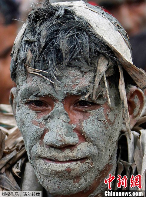 菲律宾庆祝传统宗教节日 民众全身涂满泥巴树叶参加