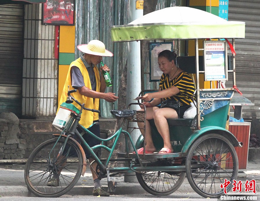 重庆高温 人力三轮车夫各有"高招"战酷暑
