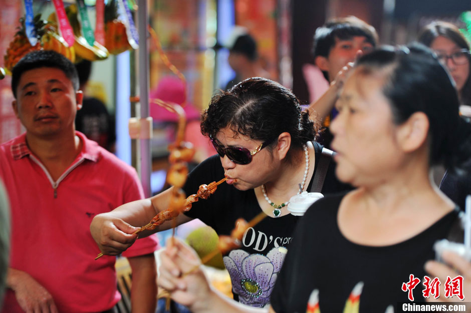 图为游客边走边吃.王东明摄