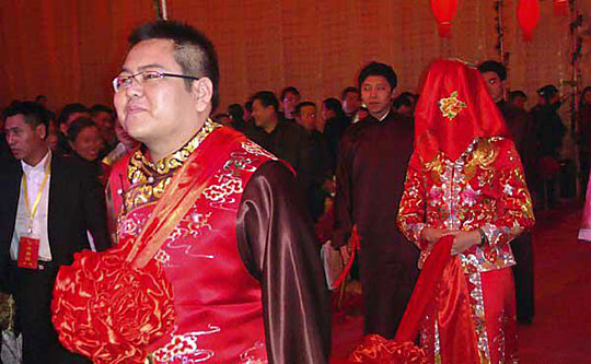 新郎李兆会用红绳牵着新娘车晓走进婚礼现场.薛俊 摄