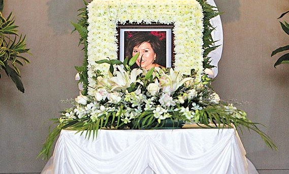 灵堂布置素雅,白色鲜花装饰的遗照下是罗慧娟的白色棺木.