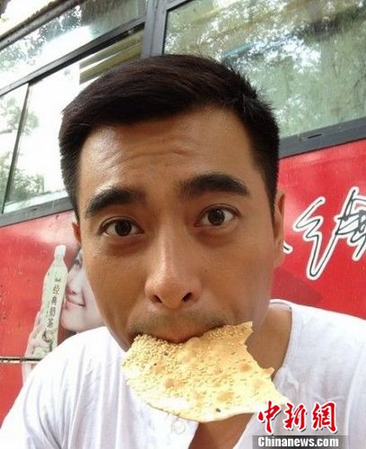 陈龙外地拍戏不舍妻儿路边吃烧饼瞪眼卖萌(图)