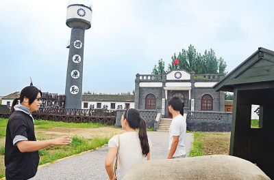 图为影视基地工作人员正在向游客介绍民国城情况